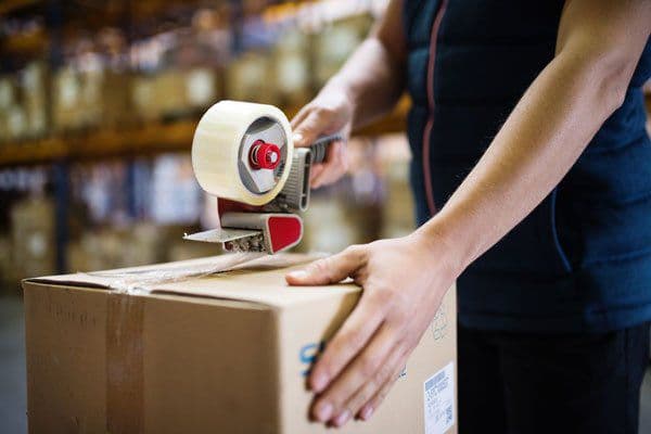 Cartons being taped during pack-out after labelling and QC.