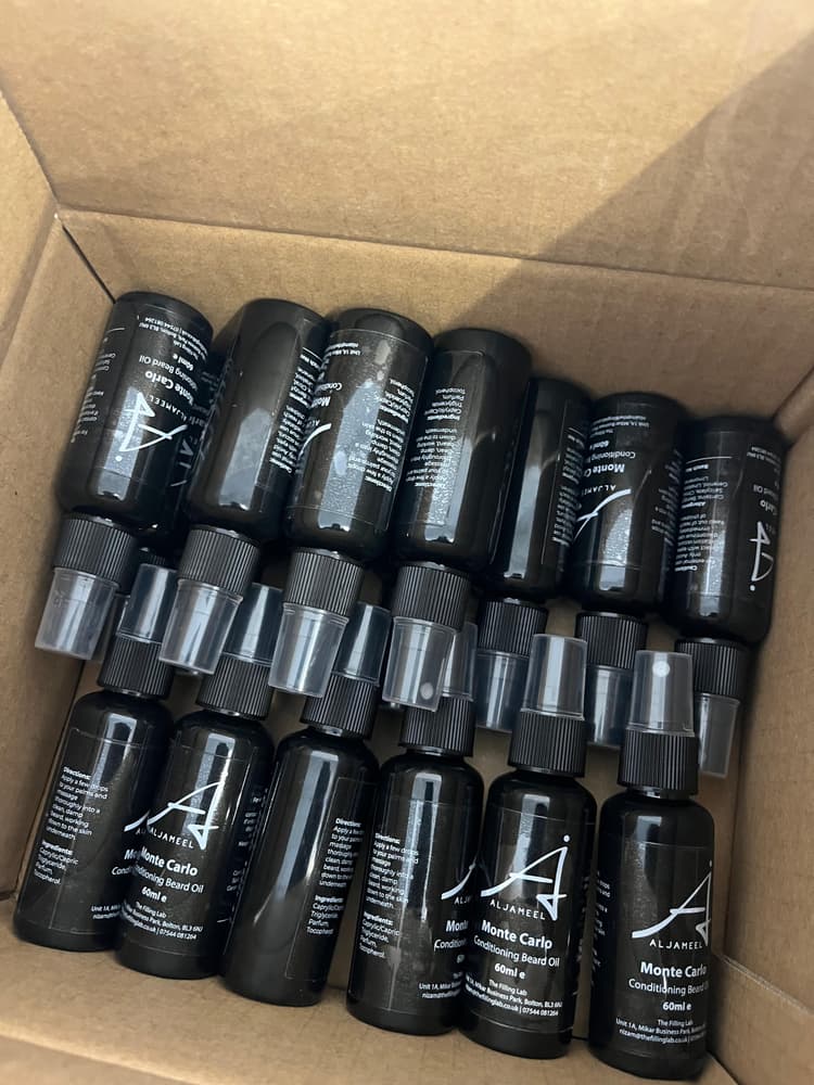 Labelled beard oil bottles packed into cartons ready for dispatch.