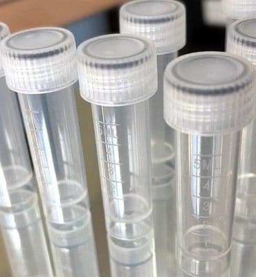 Graduated plastic vials with white caps for pharmaceutical and wellness packs.