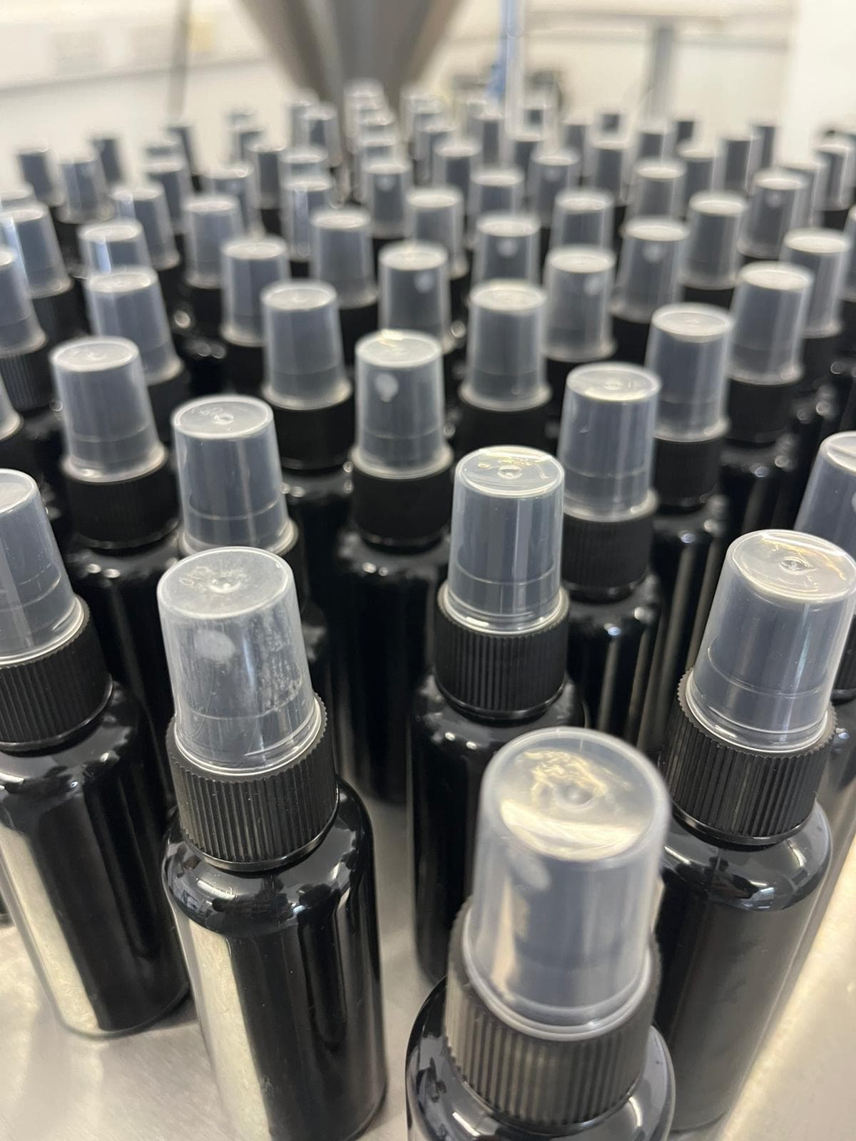 Batch of finished retail spray bottles - Luxury fragrance presentation after mixing, filtration and fill.