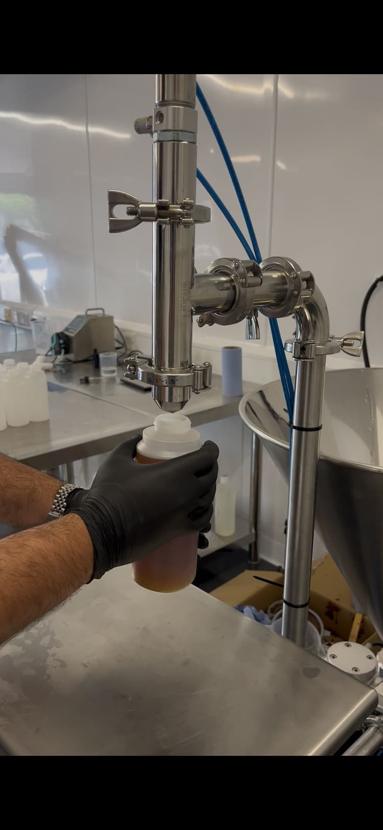 Close-up of a semi-automatic fill nozzle and tooling on the line.