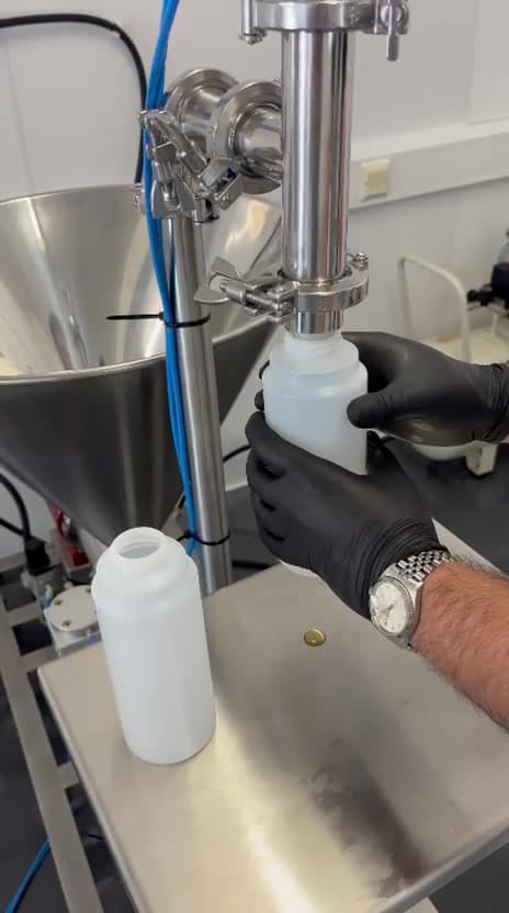 Lab formulation with pipette and plant mixing context - Controlled blending before a fragrance scale-up fill.